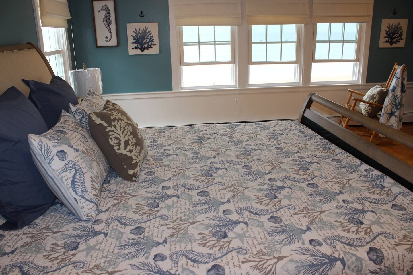 A bedroom with a bed, pillows, a nightstand, and a window with blinds.