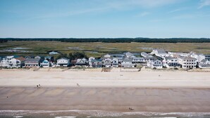 Een kustgebied met woonhuizen aan het strand, heldere luchten en uitzicht op de oceaan.