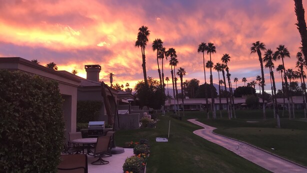 A landscaped outdoor area with a patio, seating, and a winding path. - Stunning elevated mountain and lake views at Palm Valley Country Club! (Palm Desert)