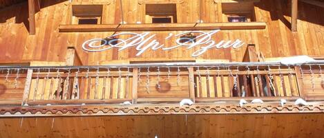 A wooden hotel facade with a sign reading "HOTEL" and "Alp Haus".
