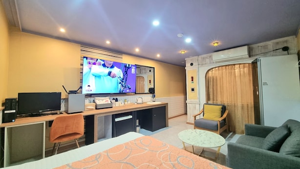 A hotel room with a TV, a desk, a sofa, and a bed. - Tirol Motel (Ulsan)
