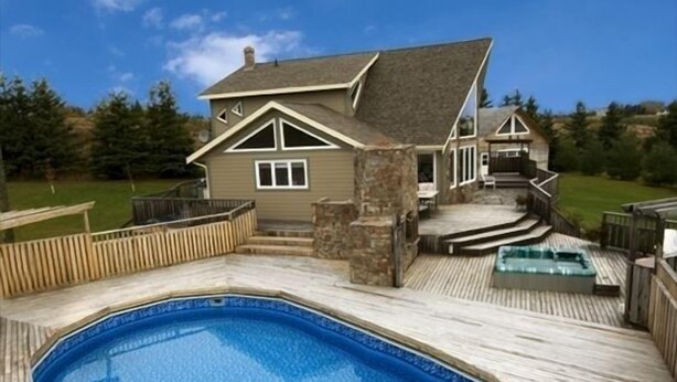 A house with a wooden deck, a swimming pool, and a hot tub. - Luxury House in the Cavendish Area with Pool, Hot Tub and Air Conditioning (Stanley Bridge)
