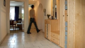 Un couloir avec une armoire en bois et un miroir.