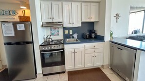 A compact kitchen with white cabinets, a stainless steel refrigerator, a stove, and a dishwasher. - 2 night minimum. Discounts all year. 1 bedroom oceanfront. Great location. Pool. (North Myrtle Beach)