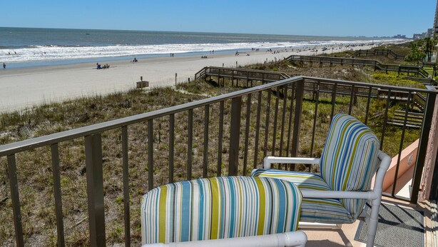 A balcony with a view of the beach and ocean. - 2 night minimum. Discounts all year. 1 bedroom oceanfront. Great location. Pool. (North Myrtle Beach)