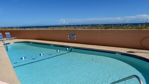 A swimming pool with a lifeguard duty sign, lounge chairs, and a view of the beach. - 2 night minimum. Discounts all year. 1 bedroom oceanfront. Great location. Pool. (North Myrtle Beach)