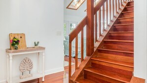 A wooden staircase with a white wall and a wooden console table with decorative items. - Charleston-area 3BR, Close to Beach or Downtown, Walk to Shem Creek (Mt Pleasant)