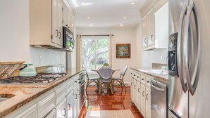 A modern kitchen with white cabinets, stainless steel appliances, and a wooden countertop. - Charleston-area 3BR, Close to Beach or Downtown, Walk to Shem Creek (Mt Pleasant)