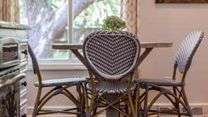 A dining area with a table and chairs, a painting on the wall, and a window with curtains. - Charleston-area 3BR, Close to Beach or Downtown, Walk to Shem Creek (Mt Pleasant)