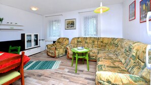 A living room with a sofa, chairs, a dining table, and a cabinet. - Bacvice Beach Apartment (Split)