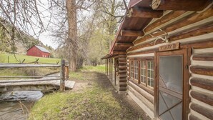 Eine rustikale Holzhütte mit einem Moskitonetz und einem Holzschild mit der Aufschrift 'TLAZY B'.