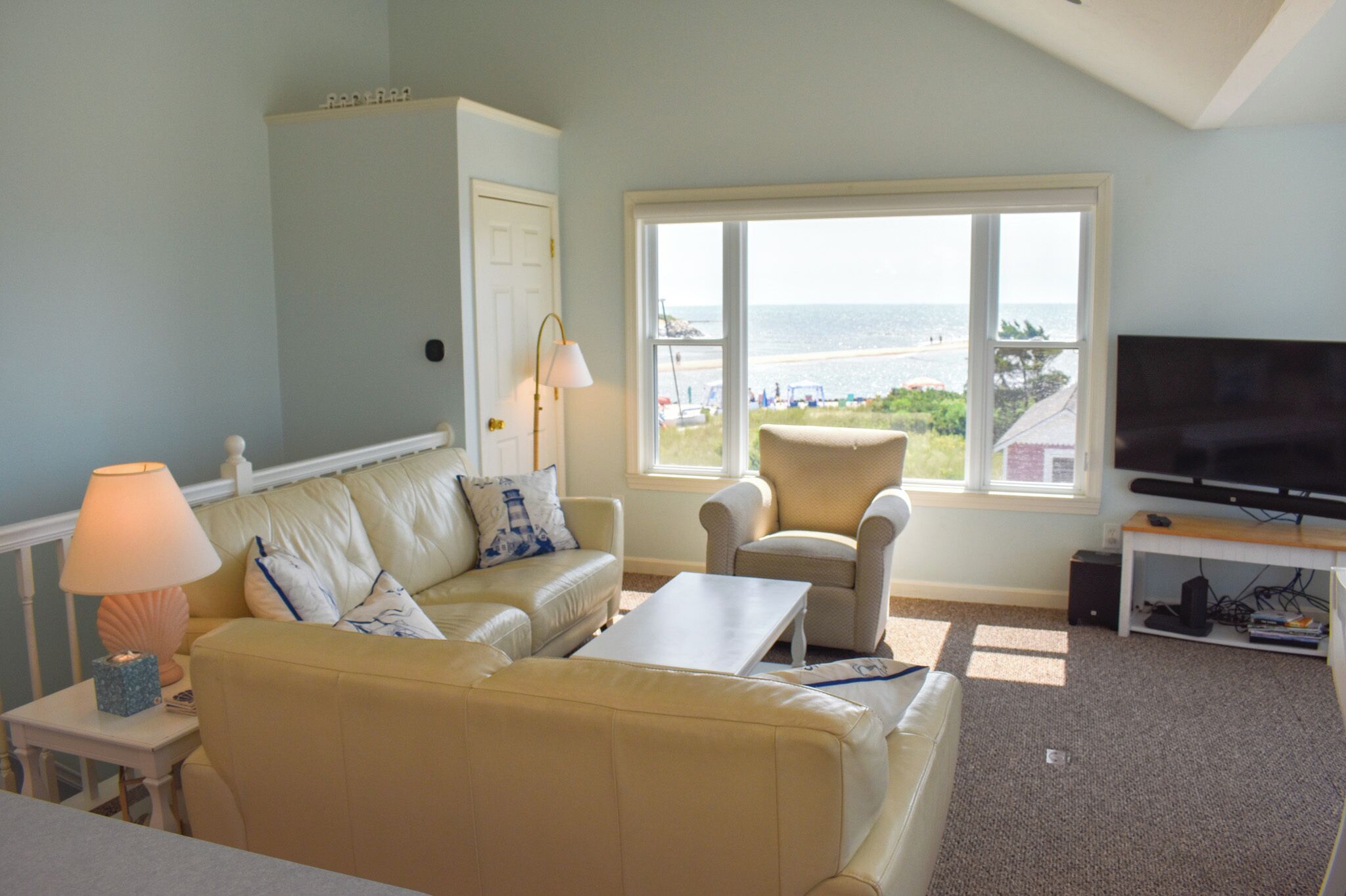 A living room with a sofa, armchair, and a television.