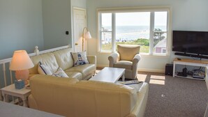 Una sala de estar con un sofá, un sillón y un televisor.