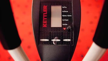 Una cyclette KETTLER nera con display digitale, pulsanti di controllo e sensore per la frequenza cardiaca.