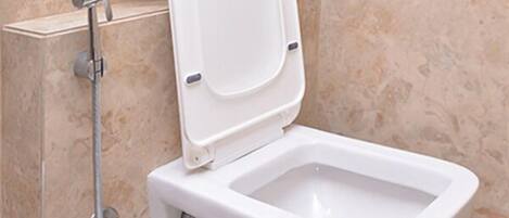A modern bathroom with a bidet, a toilet, and a shower.