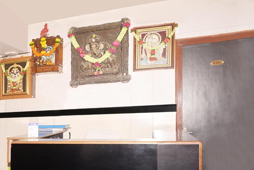 Una habitación con un escritorio, una puerta y decoraciones religiosas en la pared.