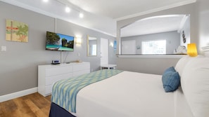 Relax in a spacious room with a large bed, flat-screen TV, and full-length mirror.