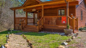 Una baita di legno con un portico, un cartello con la scritta 'Fireside Chalets' e il numero '71' sulla porta.