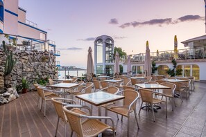 A rooftop terrace with outdoor seating, stone walls, and a view of the city. - Villa List Hotel (Sozopol)