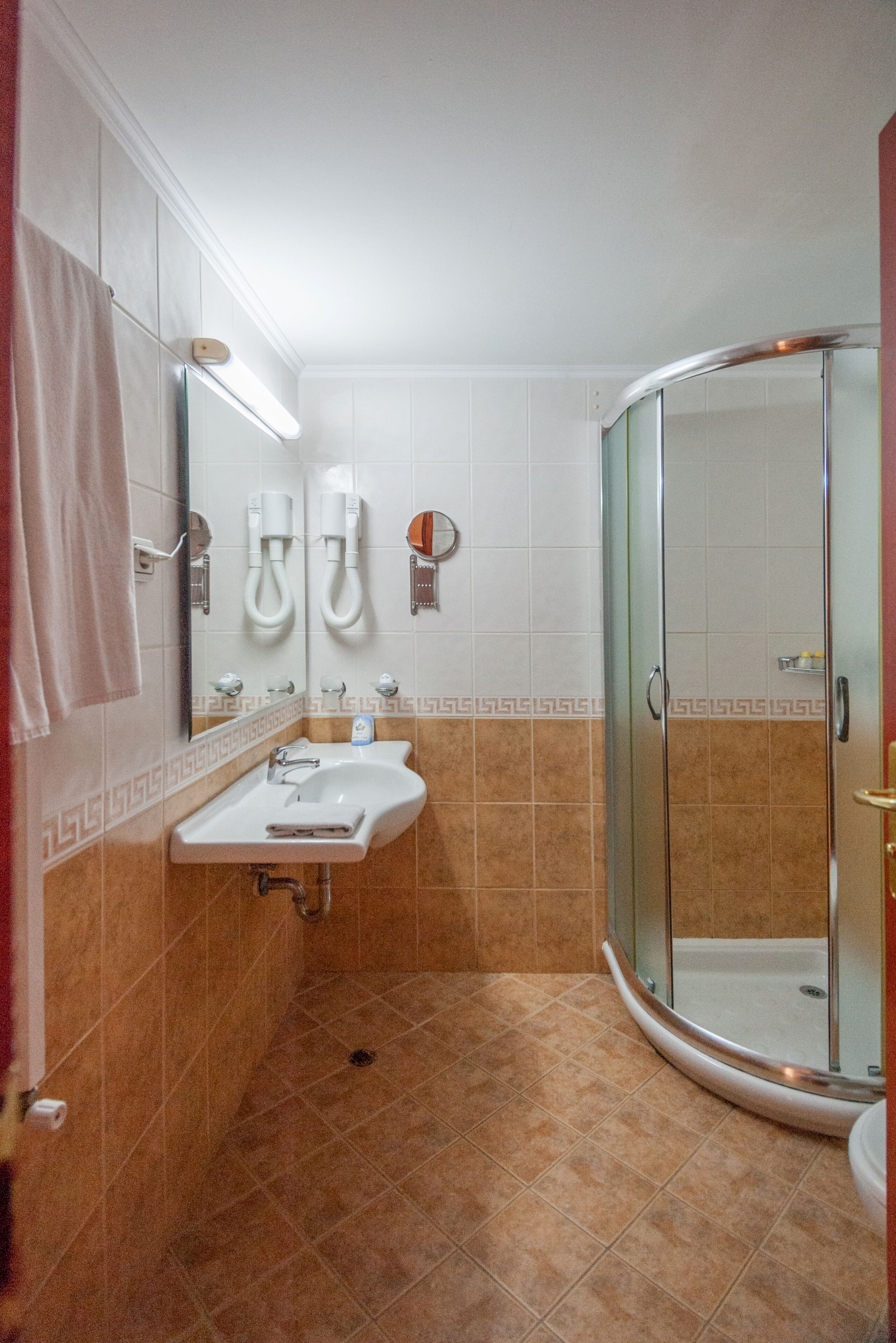 Un baño con ducha de vidrio, lavabo y espejo.