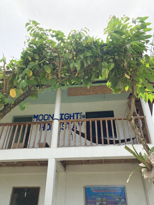 Un balcón con un cartel que dice Moonlight Inn.