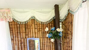 Una habitación rústica con una pared de madera, una mesita, un banco, un espejo y una planta en maceta.
