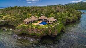 A tropical island resort with thatched-roof villas, a central pool, and lush greenery. - WAVI Paradise, Private Luxury Island - 1 to 6 guests (Savusavu)