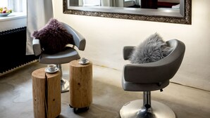 A modern room with a large mirror, a hairdressing chair, and two wooden stools. - Wake Up Wellness Hostel by goodnite cz (Brno)