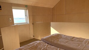 A cabin with two beds, a window, and wooden walls. - Sunnuhlid houses (Akureyri)