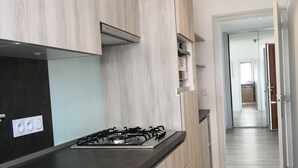 A modern kitchen with light wood cabinetry, a black countertop, and a gas stove. - Panoramic view  (La Baule-Escoublac)