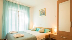 Ein Schlafzimmer mit einem Bett, einem Nachttisch, einem Kleiderschrank und einem Bild an der Wand.