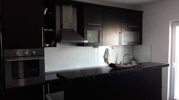 Appartement, 3 slaapkamers, balkon | Privékeuken | Een koelkast, een microgolfoven, een oven, een kookplaat
