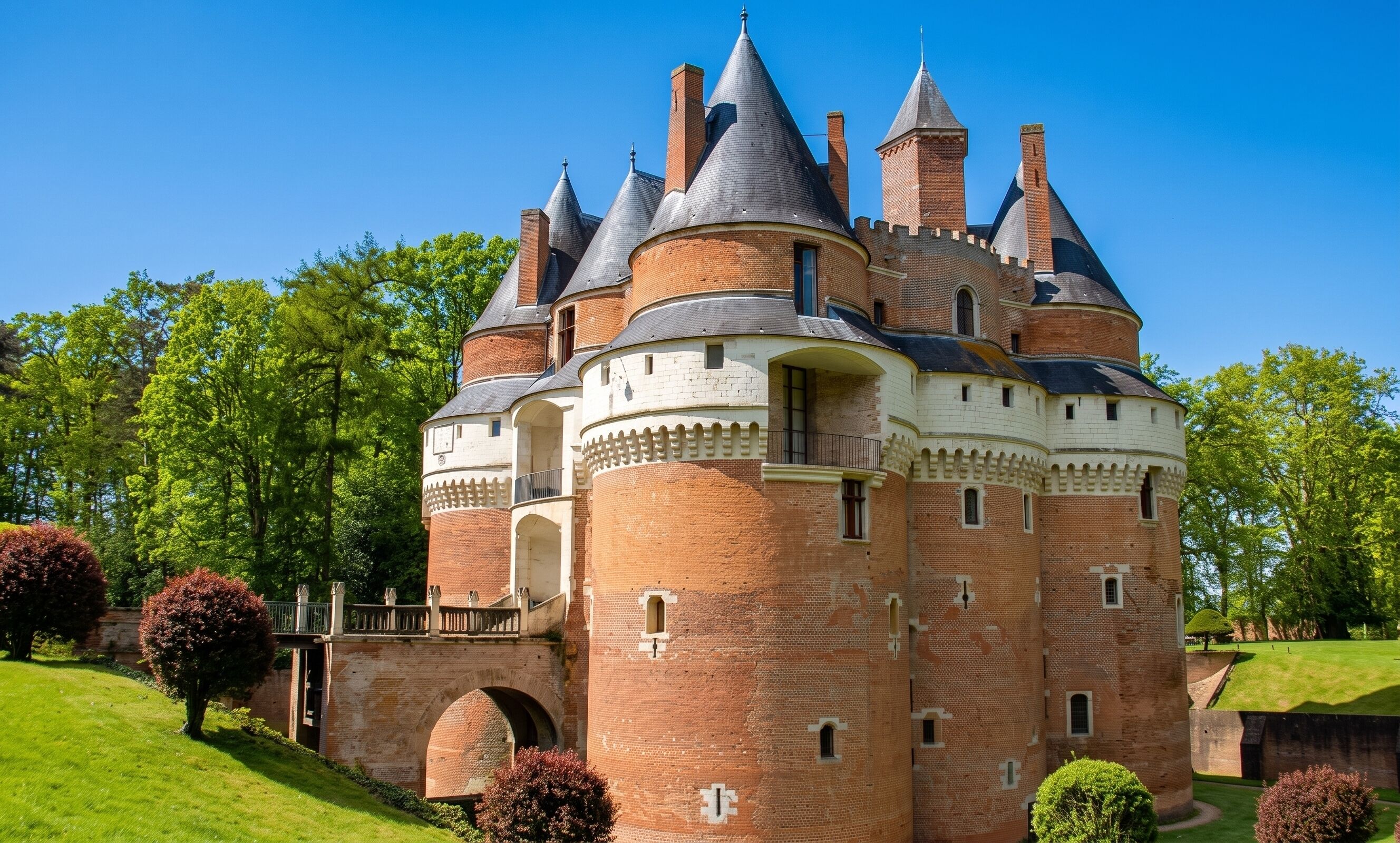 Um castelo com várias torres, um pátio central e um jardim ao redor.
