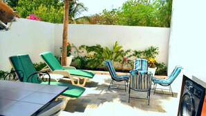 A patio with lounge chairs, a table, and a washing machine. - Villa Kadia Paradis 2 (Saly)