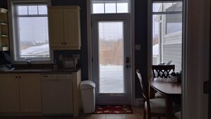 Una cocina con lavavajillas, pileta y ventana con persianas.