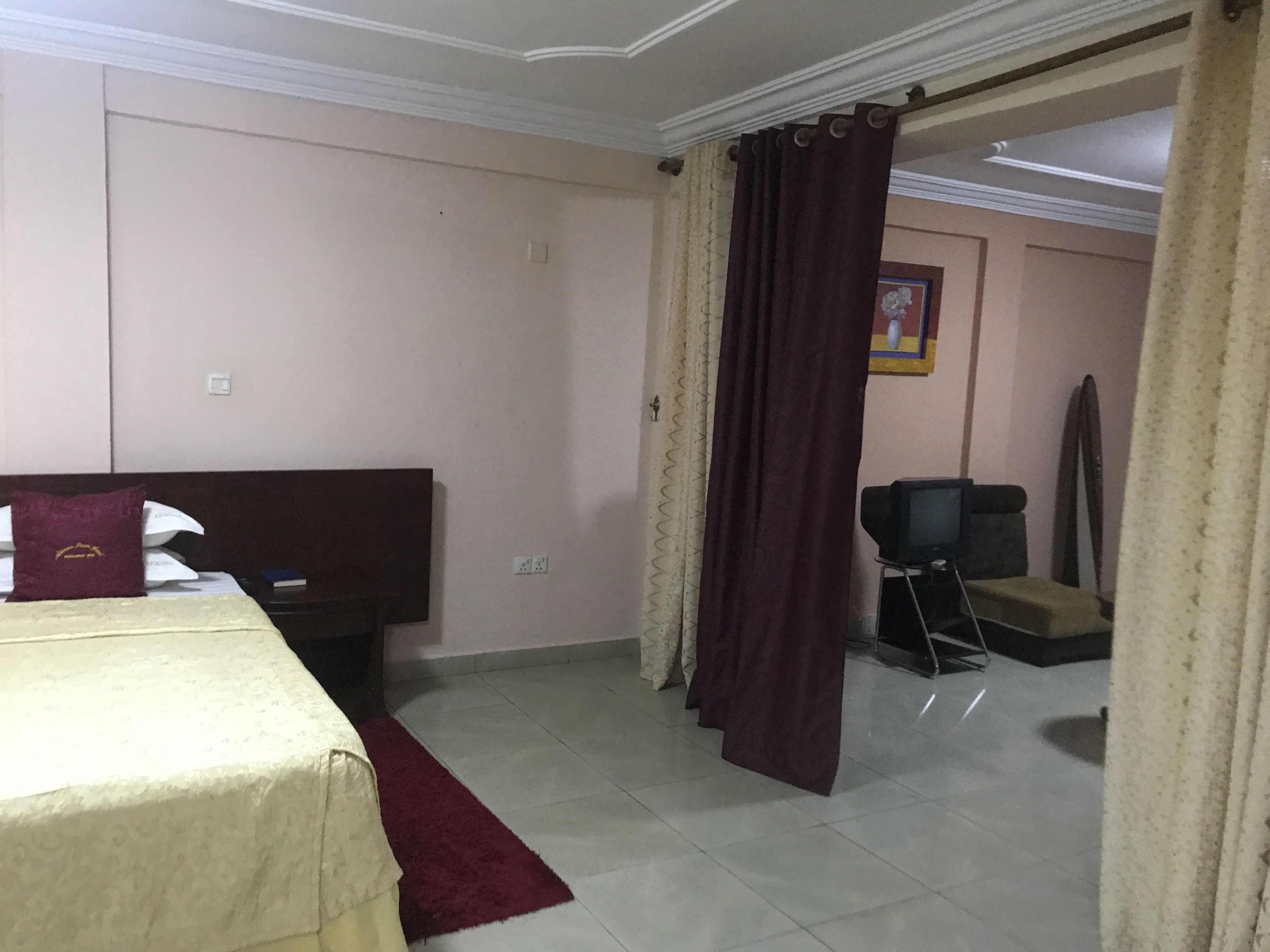 A hotel room with a bed, a television, and a chair.
