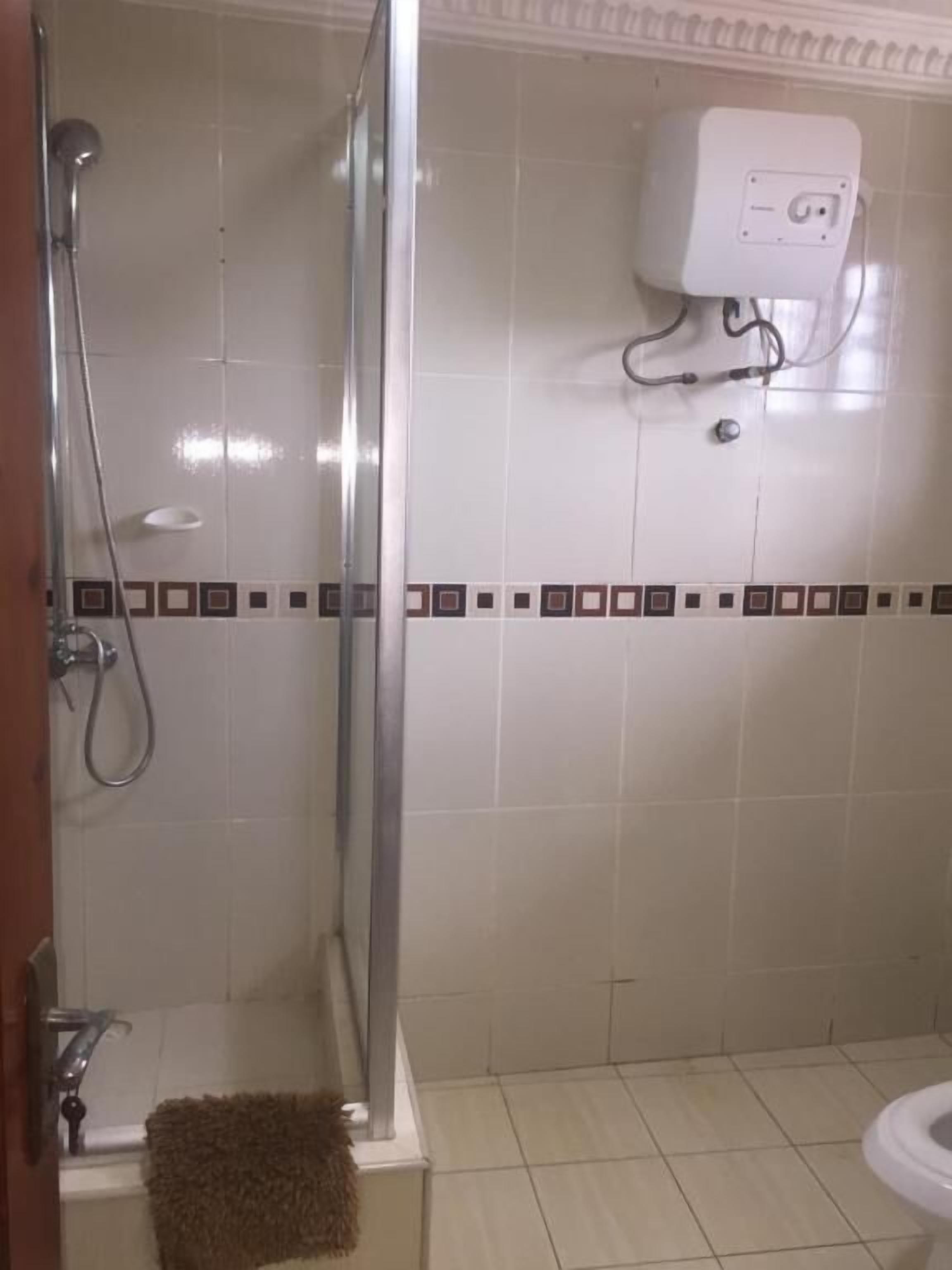 Ett badrum med en dusch som är avskärmad med glasväggar, en toalett och en handduksställning.