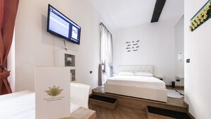 A hotel room with a bed, a desk, a television, and a wall with a motivational quote. - Hemeras Boutique House Aparthotel Duomo 6 (Milan)