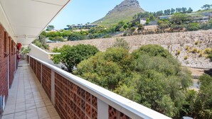 A balcony with a view of a mountain and surrounding greenery. - Harbour Lights 306 - Adults Only (Cape Town)