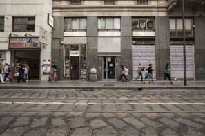 Straßenansicht mit einem Gebäude, auf dem 'ISTITUTO DI BELLEZZA' steht, und einem Geschäft namens 'Kappa'.