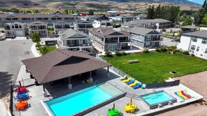 Una zona residencial con casas modernas, piscina y un patio cubierto.