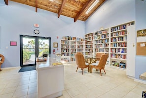Cozy library with a high ceiling, round table, and bookshelves.