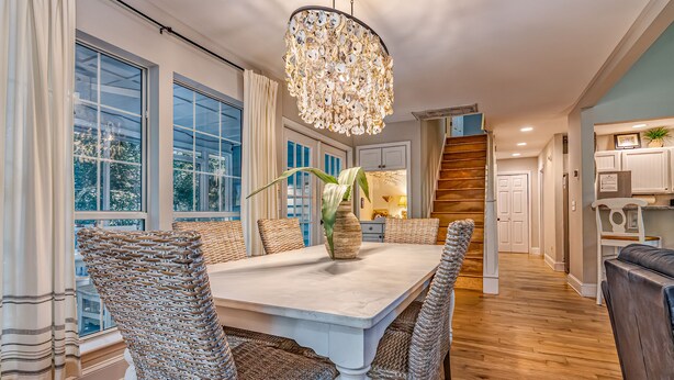 A dining area with a large table, wicker chairs, and a decorative vase.