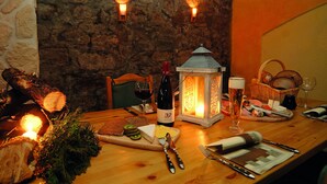 A wooden table with a bottle of wine, a candle, and a lantern. - Landhotel zur Post (Schoenheide)