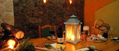 Una mesa de madera con una botella de vino, una vela y un farol.