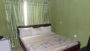 A bedroom with a bed, a nightstand, and a desk. - Terris Hotel and Suites (Lagos)