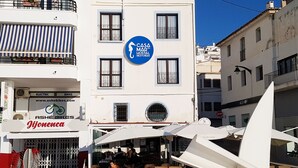 A building with a sign for "Casa del Mad Hostel Restobar" and a nearby "Ashé Bikes" shop. - Hostal Casa del Mar (Altea)