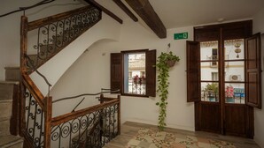 A staircase with a wooden railing and a patterned floor. - Hostal Casa del Mar (Altea)