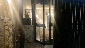 An open door leading to a room with a stone wall and a wooden fence. - Dolce Vita Casa Vacanze (Carini)