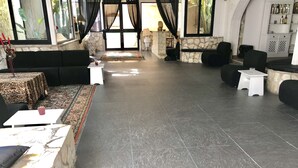 A spacious indoor area with a stone wall, black leather sofas, and a patterned rug. - Dolce Vita Casa Vacanze (Carini)